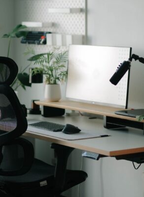 Un espace de travail ergonomique et moderne avec chaise de bureau noire et plantes vertes.