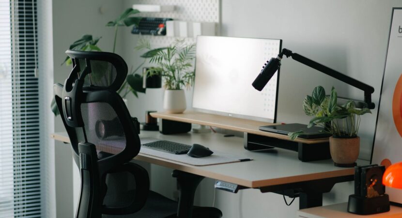 Un espace de travail ergonomique et moderne avec chaise de bureau noire et plantes vertes.