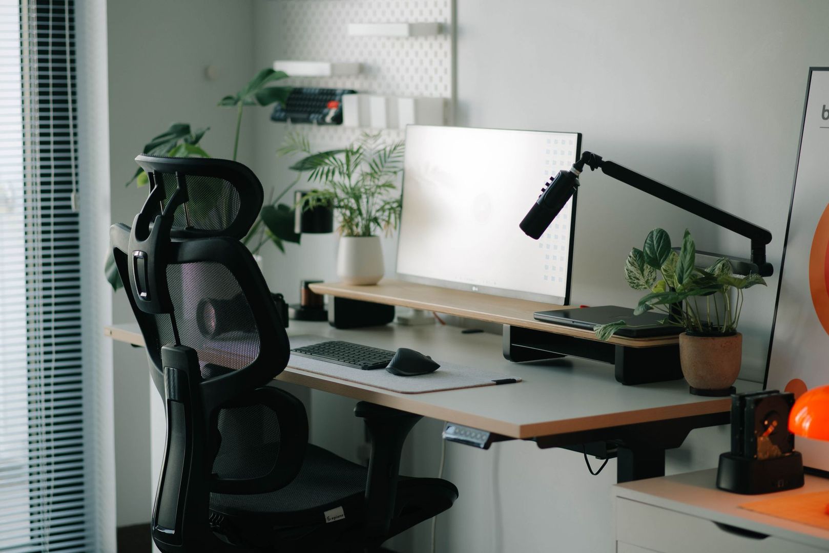 Un espace de travail ergonomique et moderne avec chaise de bureau noire et plantes vertes.